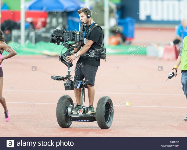 camera-operator-standing-on-a-segway-and-equipped-with-steadicam-camera-E04FGP.jpg